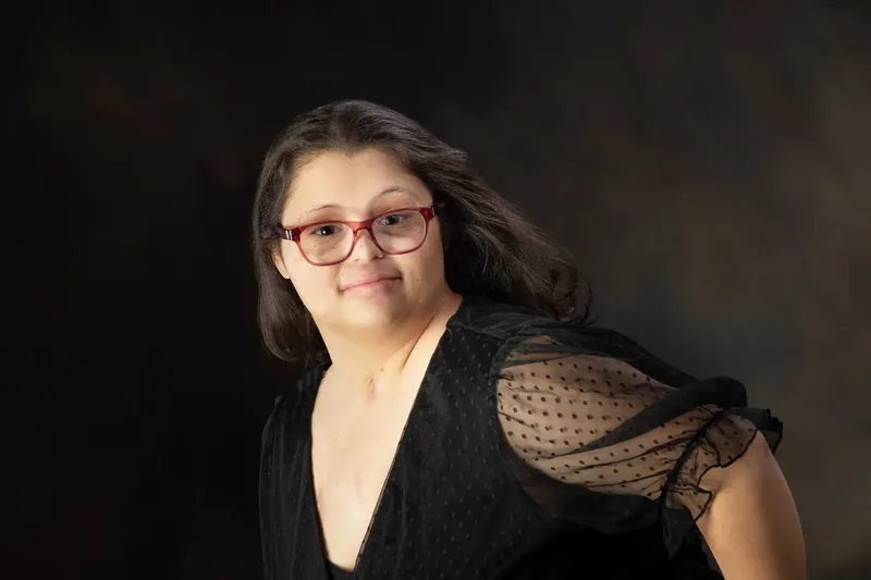 Studio portrait of Danielle Robinson in a black dress, smiling.